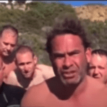 shirtless men squinting into the sun looking at the camera