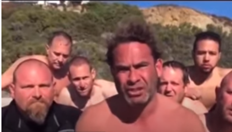 shirtless men squinting into the sun looking at the camera